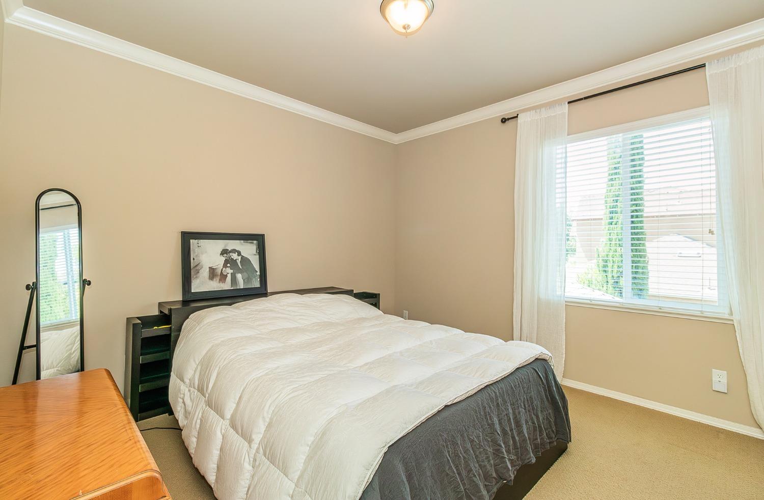 4179 Harlan Ranch Boulevard Clovis, CA 93619 - Photo 18 of 47 a spacious bedroom with a bed and a window