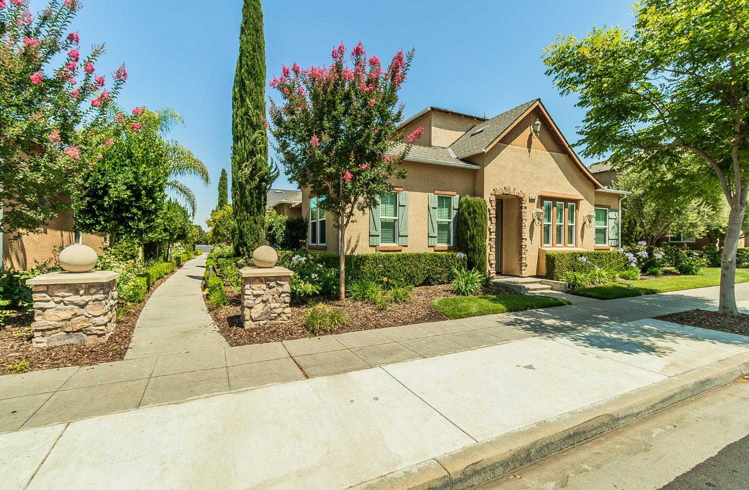 4179 Harlan Ranch Boulevard Clovis, CA 93619 - Photo 25 of 47 a front view of a house with a yard and potted plants