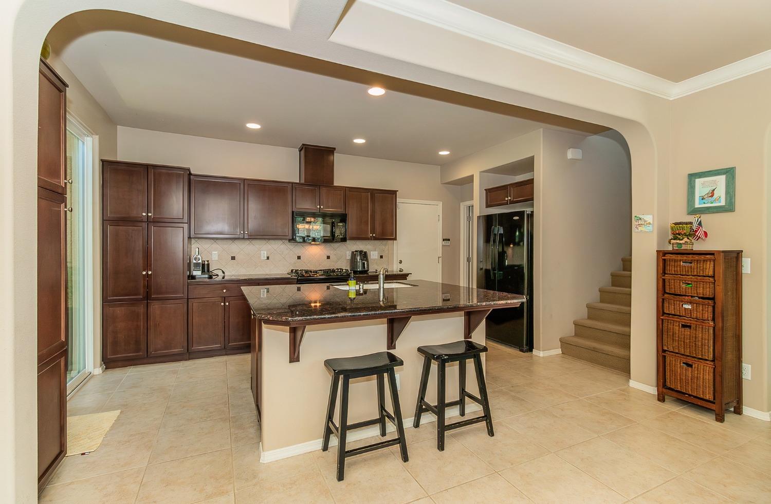 4179 Harlan Ranch Boulevard Clovis, CA 93619 - Photo 3 of 47 a kitchen with stainless steel appliances kitchen island granite countertop a refrigerator and a stove top oven