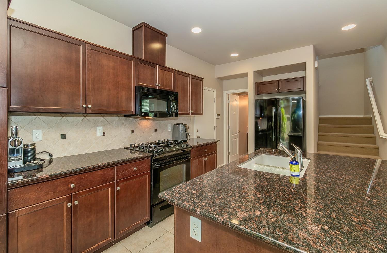4179 Harlan Ranch Boulevard Clovis, CA 93619 - Photo 4 of 47 a kitchen with stainless steel appliances granite countertop a sink stove and refrigerator