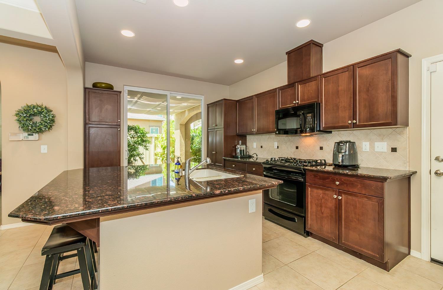 4179 Harlan Ranch Boulevard Clovis, CA 93619 - Photo 5 of 47 a kitchen with stainless steel appliances granite countertop a stove sink microwave and refrigerator