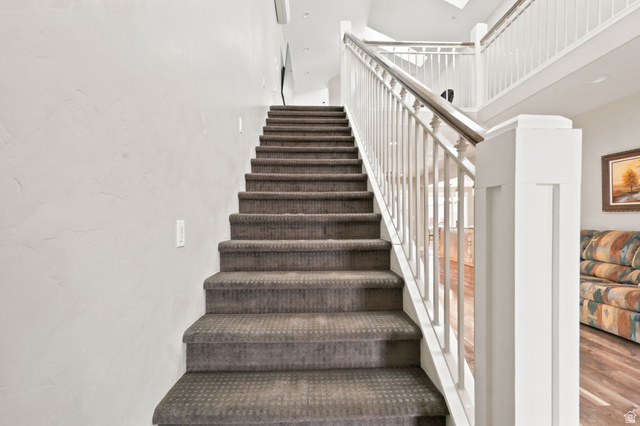 580 North 300 East Logan, UT 84321 - Photo 47 of 74 Carpeted staircase with white balusters and a wood-finish handrail leading to an upper level.