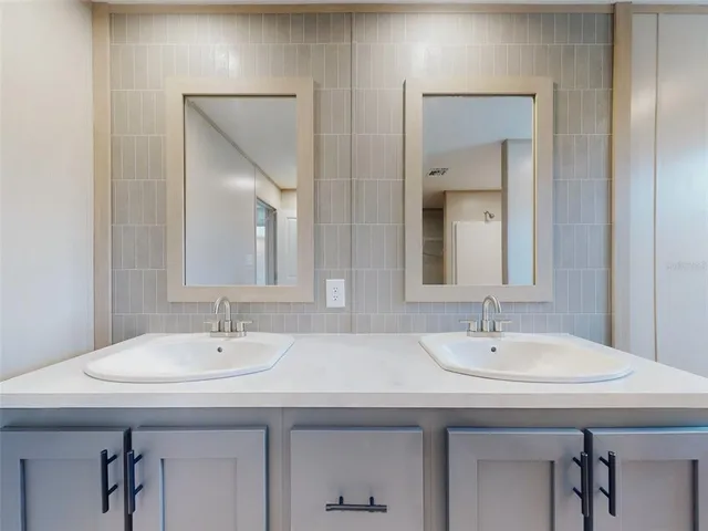 a bathroom with double sink and a mirror