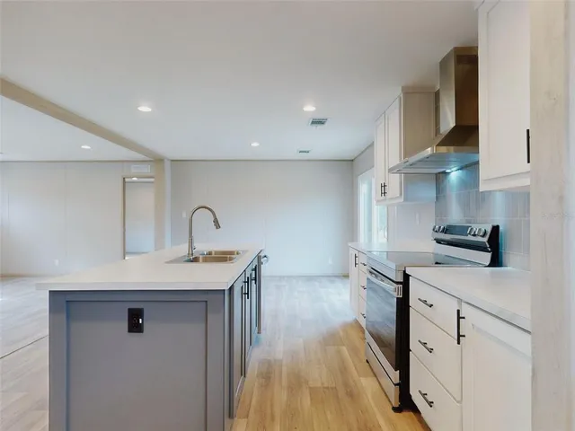 a kitchen with stainless steel appliances a sink stove and cabinets