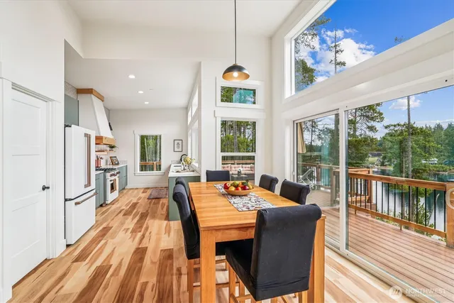 a dining room with furniture a large window and wooden floor