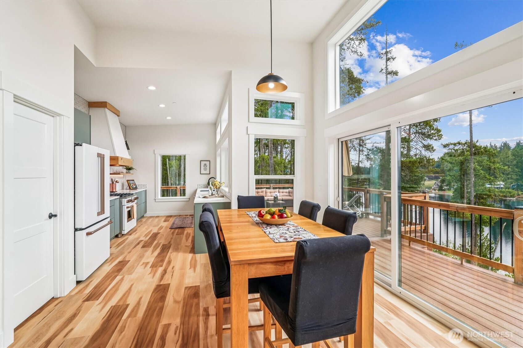 9705 117th Avenue Anderson Island, WA 98303 - Photo 14 of 40 a dining room with furniture a large window and wooden floor