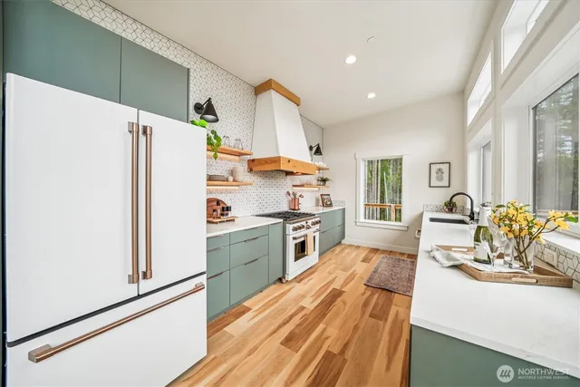 a kitchen with stainless steel appliances a refrigerator and a stove top oven