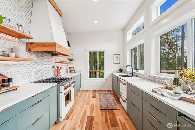 a kitchen with stainless steel appliances a sink stove and cabinets