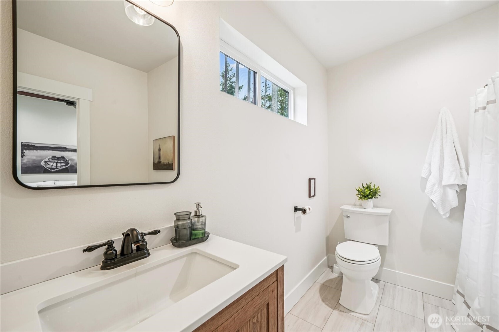 9705 117th Avenue Anderson Island, WA 98303 - Photo 25 of 40 a bathroom with a toilet a sink and a mirror