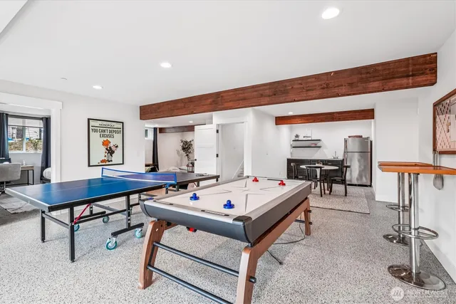 a living room with furniture pool table and windows