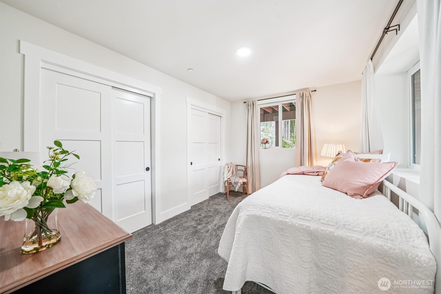 9705 117th Avenue Anderson Island, WA 98303 - Photo 32 of 40 a bedroom with a bed and a potted plant