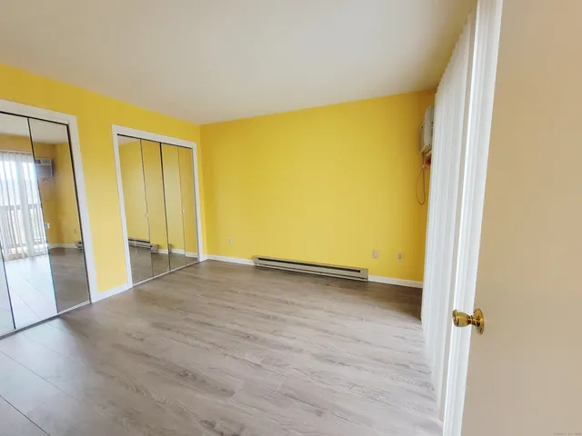an empty room with wooden floor and a window