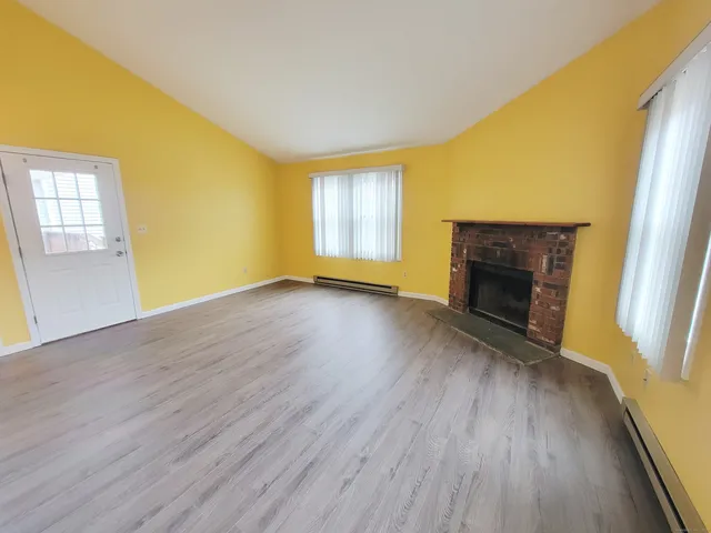 an empty room with wooden floor and a window