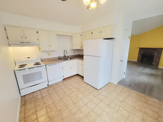 a kitchen with granite countertop white cabinets and white appliances