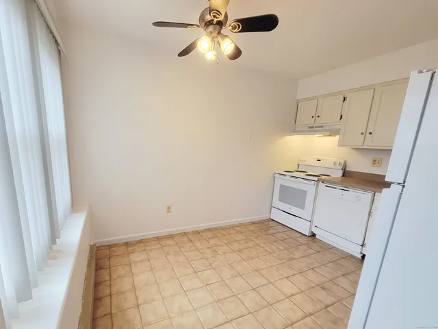 a kitchen with white cabinets and white appliances