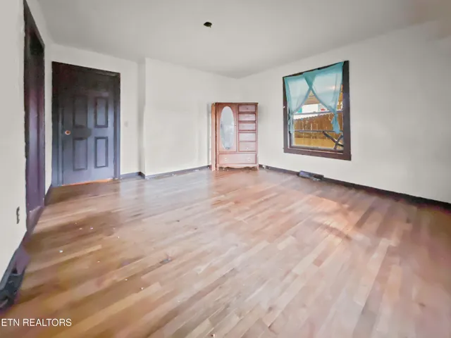 an empty room with windows and closet