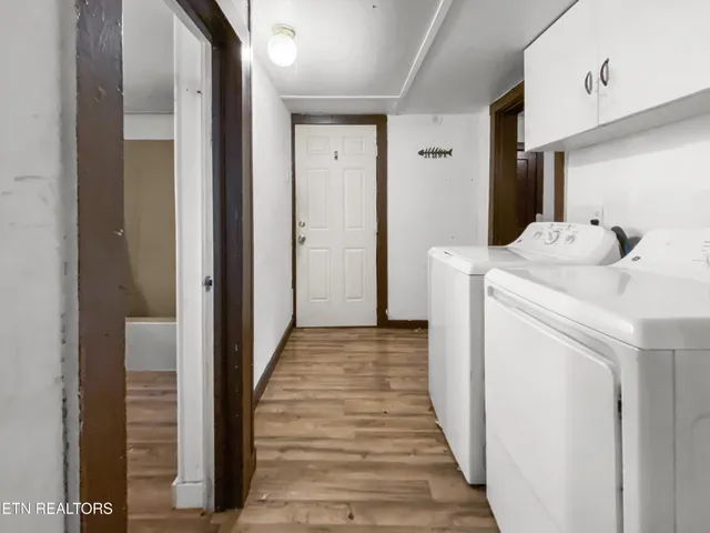 a utility room with wooden floor washer and dryer
