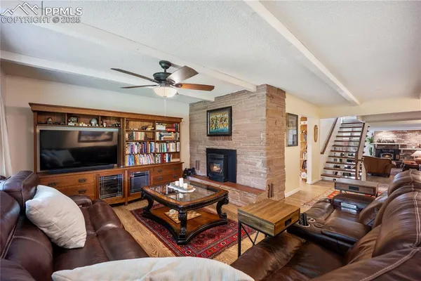 a living room with furniture a flat screen tv and a fireplace