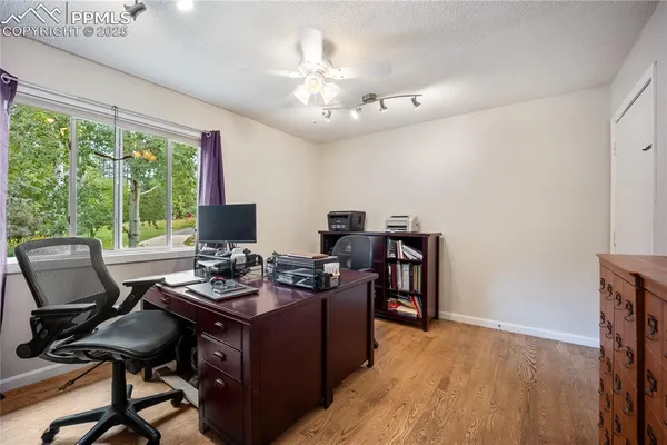 a view of a workspace with furniture and a window