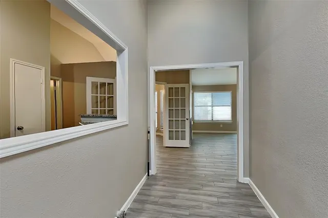 a view of a hallway with wooden floor and a living room