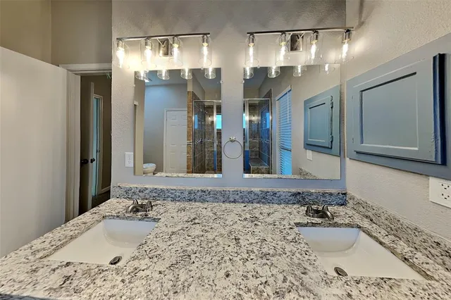 a bathroom with a granite countertop sink and a mirror