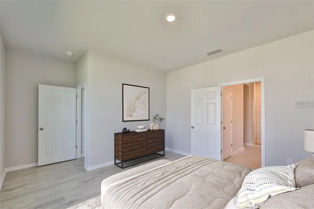 a bedroom with a bed and a potted plant