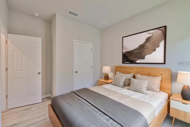 a bedroom with a bed and a painting on the wall