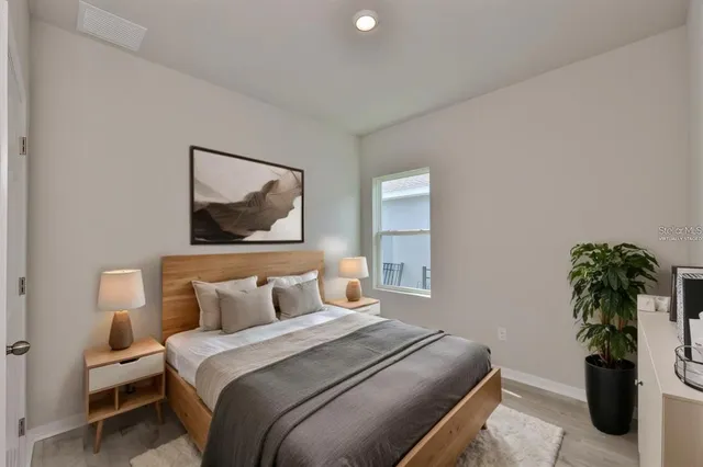 a bedroom with a bed and a potted plant