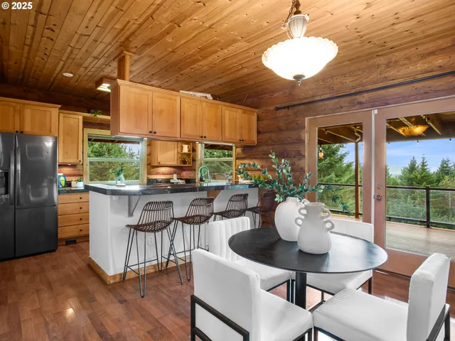 a dining room with furniture a potted plant and wooden floor