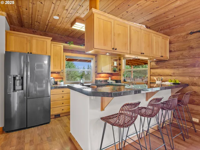 a kitchen with stainless steel appliances kitchen island granite countertop a refrigerator and microwave