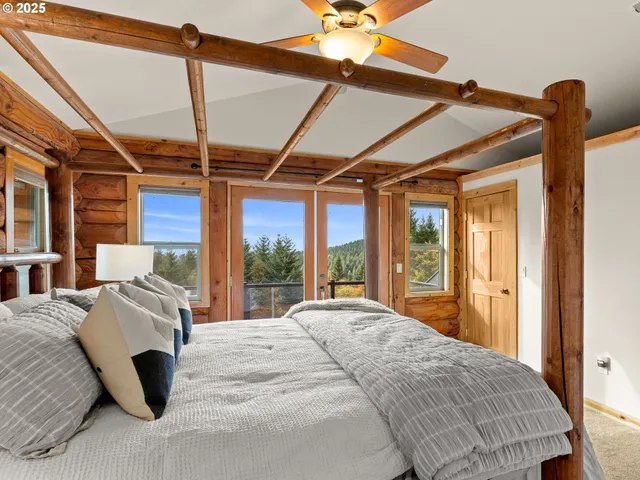 a bedroom with a bed and large windows