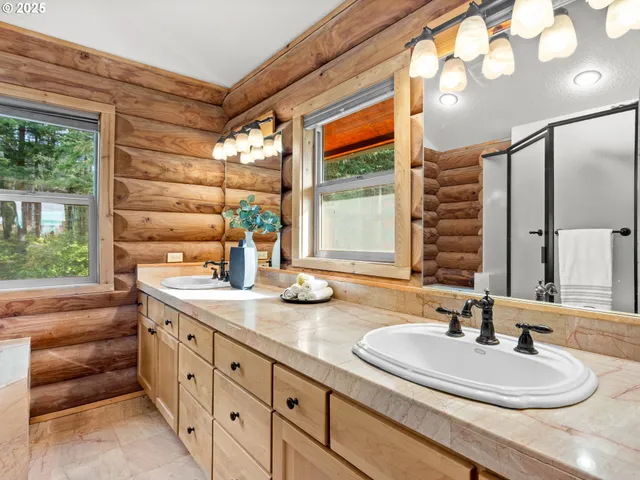 a bathroom with double vanity and a mirror