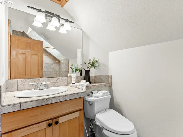 a bathroom with a granite countertop sink mirror and toilet