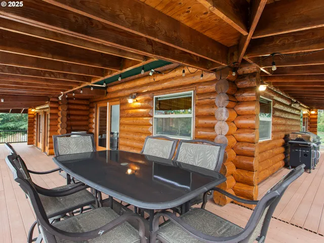 a roof deck with table and chairs with wooden floor