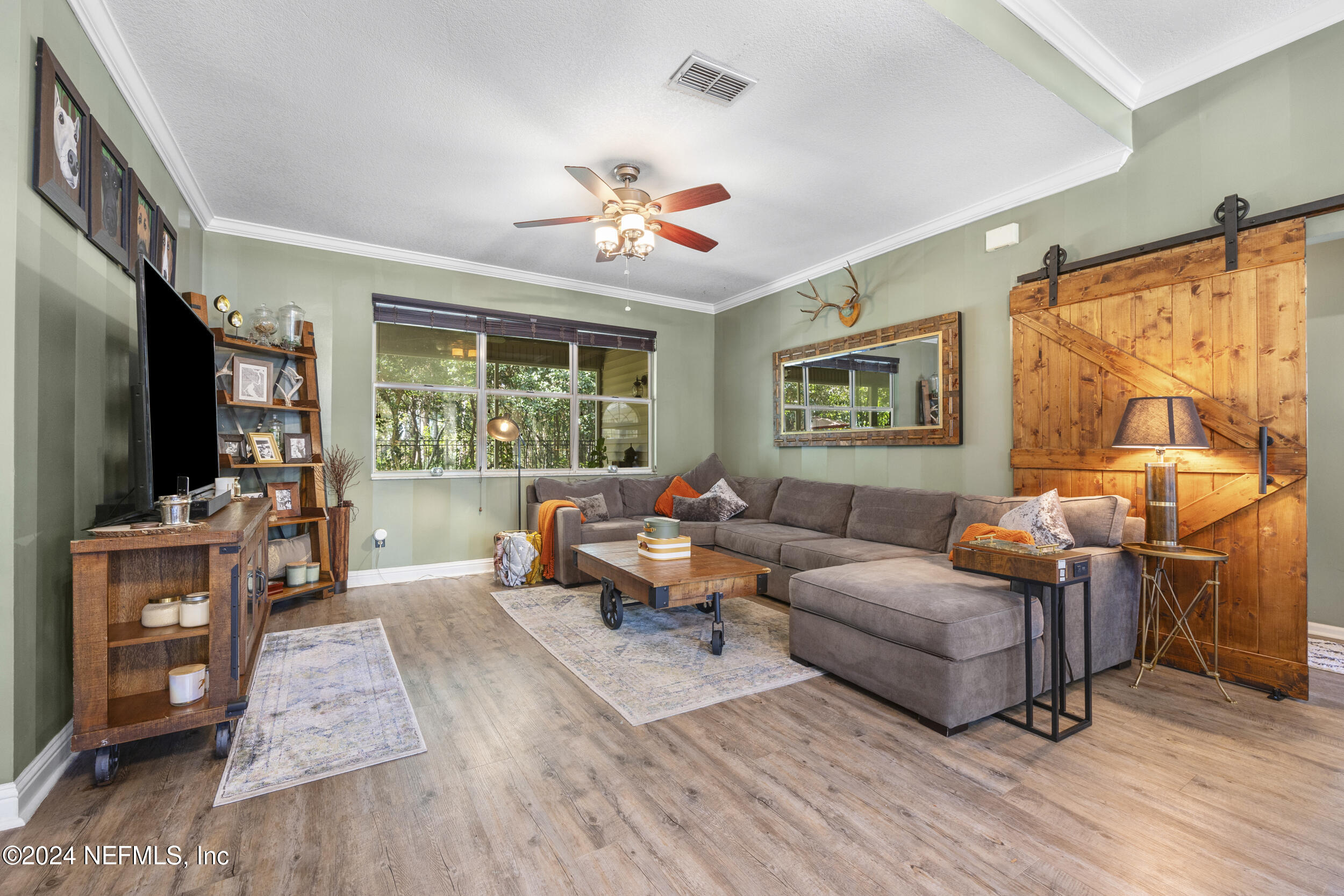 2338 Eagles Nest Road Jacksonville, FL 32246 - Photo 8 of 68 a living room with furniture a wooden floor and a flat screen tv