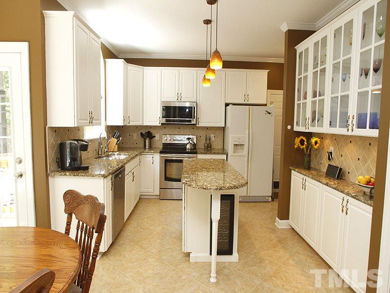 5813 Ventry Court Raleigh, NC 27613 - Photo 4 of 12 a kitchen with stainless steel appliances granite countertop a refrigerator a sink dishwasher a stove with white cabinets and wooden floor