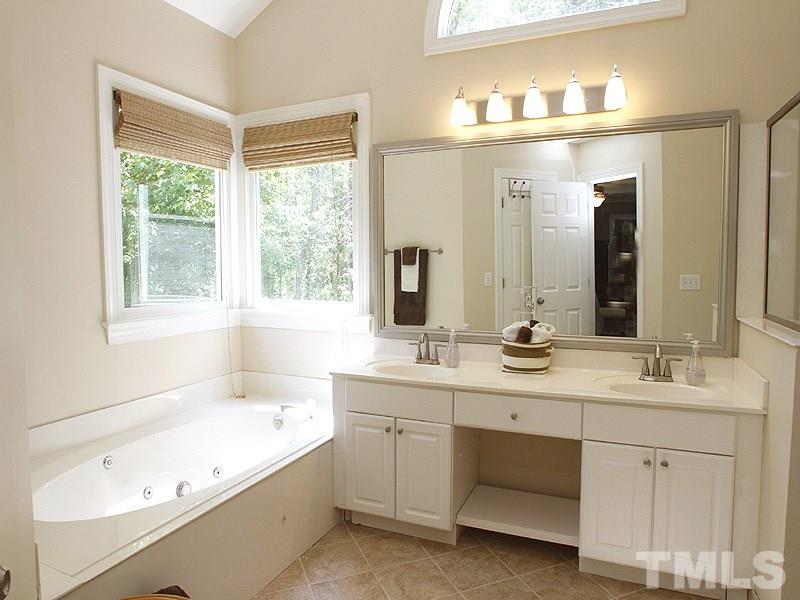 5813 Ventry Court Raleigh, NC 27613 - Photo 7 of 12 a bathroom with a tub a sink and mirror