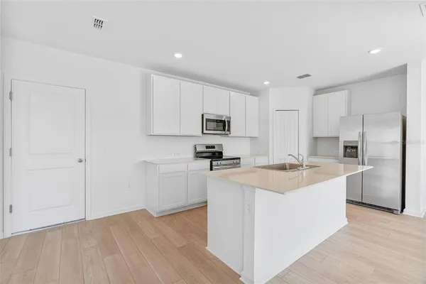 a kitchen with a sink a stove a refrigerator and cabinets