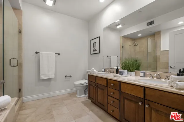 a bathroom with a double vanity sink a toilet and mirror
