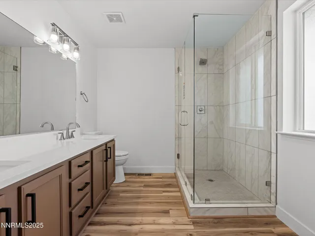 a bathroom with a double vanity sink and shower