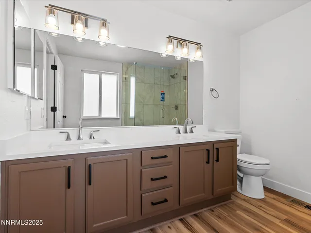 a bathroom with a double vanity sink mirror and toilet
