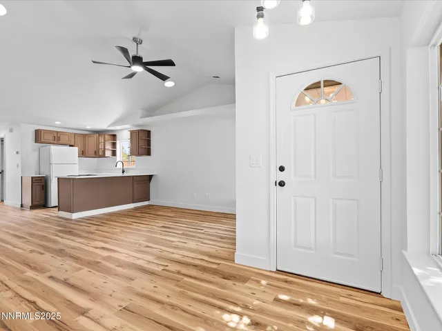 a view of an empty room with window and wooden floor