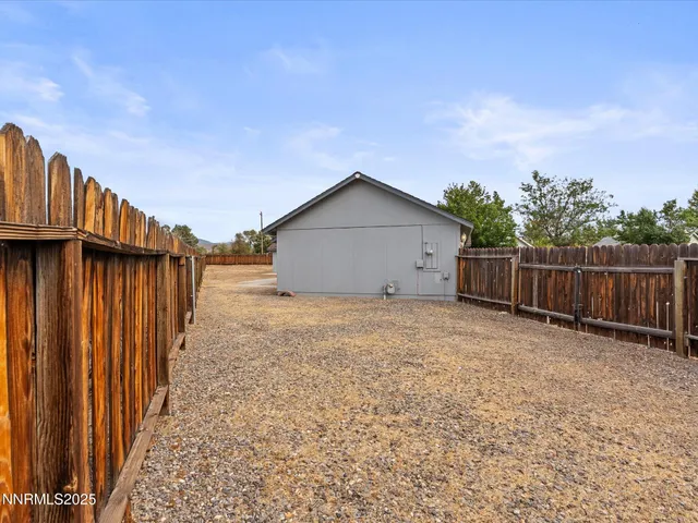 a view of backyard space with wooden fence