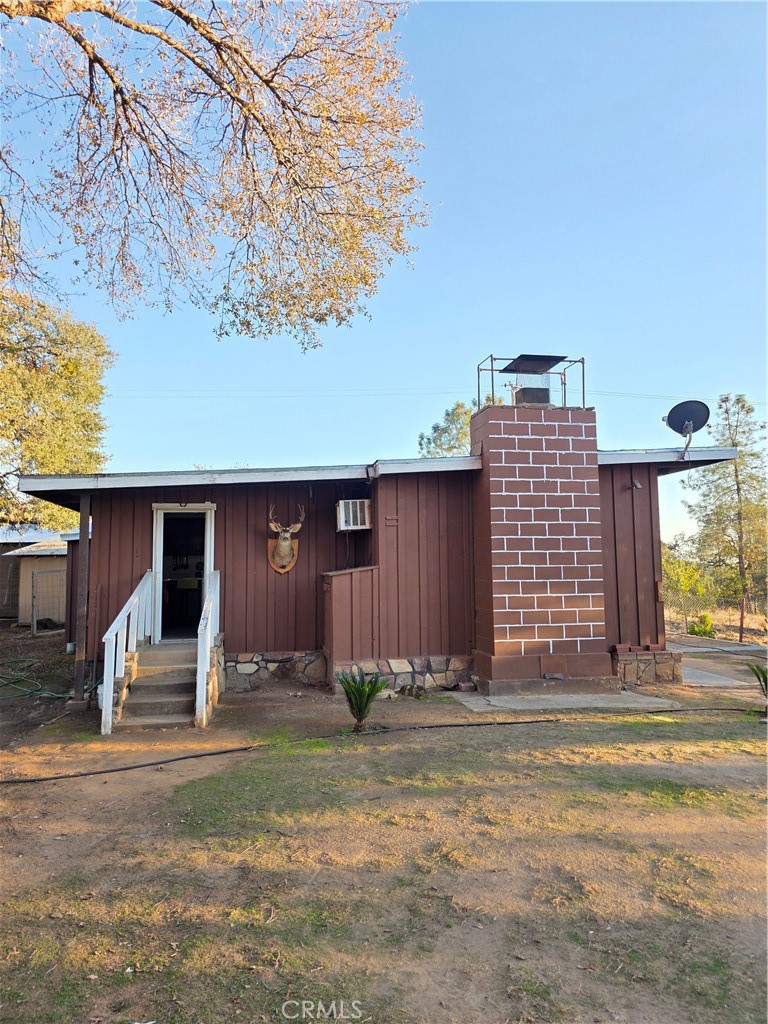 a view of a house with backyard and trees