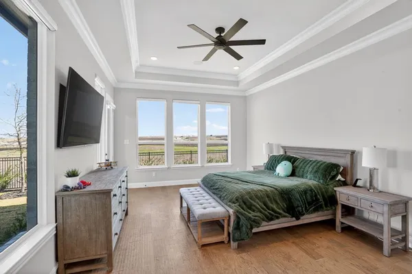 a bedroom with a bed a flat screen tv and a window