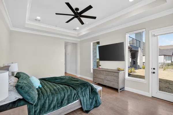 a living room with a bed furniture flat screen tv and a large window