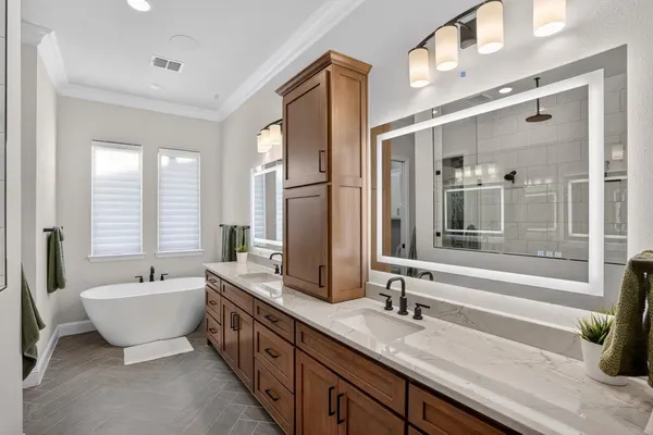 a spacious bathroom with a double vanity sink a mirror and a bathtub