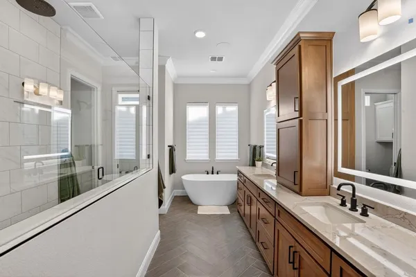 a bathroom with a double vanity sink a large mirror and a bathtub
