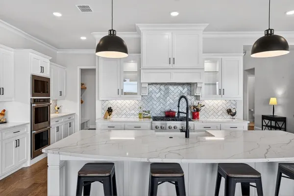 a kitchen with stainless steel appliances kitchen island granite countertop a table and chairs in it