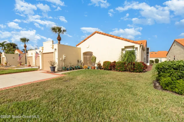 a view of a house with a backyard and a tree